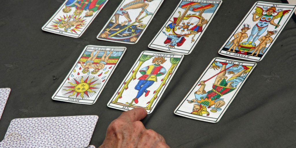a reader's hand during the reading of the playing cards and Tarot